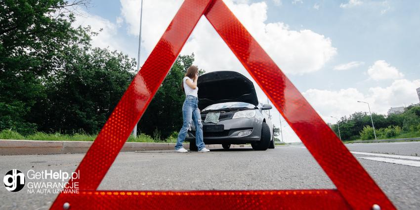 rozłożony trójkąt ostrzegawczy przed uszkodzonym samochodem